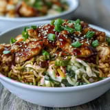 Freshly cooked Egg Roll Bowls with Chicken and Cabbage in a skillet, featuring colorful shredded carrots, green cabbage, and savory chicken.