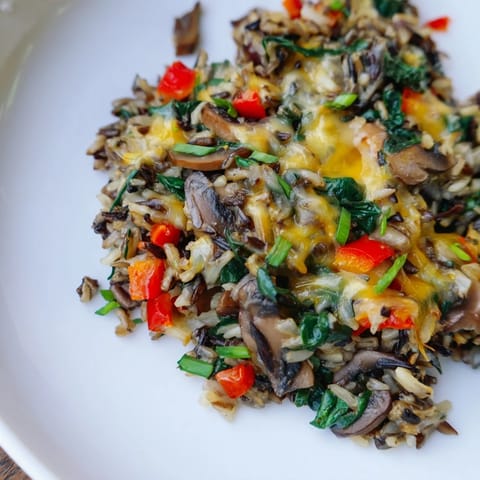 Golden-topped wild rice casserole, bubbling hot from the oven with melted cheese and fresh herbs.