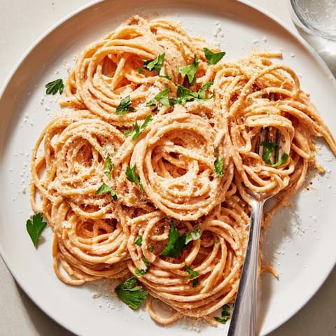 Sriracha Honey Pasta served in a bowl, featuring al dente fettuccine coated in a vibrant orange, creamy sauce.  