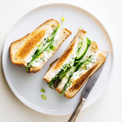 Golden-brown Whipped Feta Spring Grilled Cheese oozing with creamy dill filling, served beside fresh lemon slices.