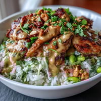 Coconut Rice Peanut Bowl with grilled chicken, fresh vegetables, and creamy peanut sauce in a vibrant, nourishing meal bowl.